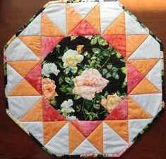 a close up of a patchwork quilt on a table top with flowers in the center