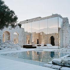 an old building with a mirrored pool in the middle