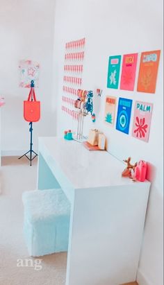 a white desk in a room with pictures on the wall