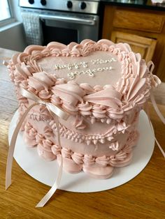 a heart shaped cake on a plate with a ribbon around the edge and words written on it