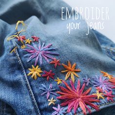 an embroidered jean jacket with colorful flowers on it