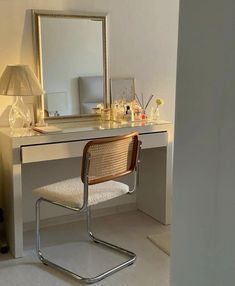 a white desk with a mirror, chair and lamp in the corner next to it