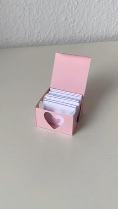 a pink box with some cards in it and a heart cut out of the inside