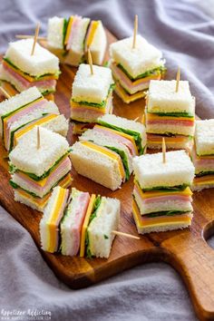 mini sandwiches are arranged on a cutting board