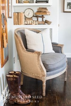 an image of a chair with pillows and boots on it in front of bookshelves