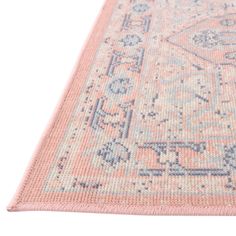 a pink rug with blue and white designs on the bottom, in front of a white background