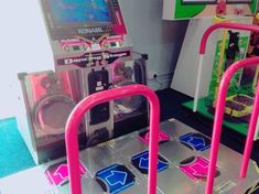 an arcade machine with pink handles next to other machines