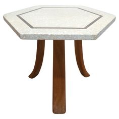 a small table with a white marble top and wooden legs, on a white background