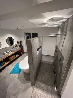 a bathroom with a walk in shower sitting next to a sink and a bathtub