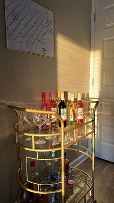 a gold bar cart filled with bottles and glasses