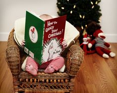 a baby sitting in a chair reading a book