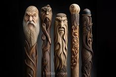 five carved wooden poles with faces and leaves on them, all lined up in a row