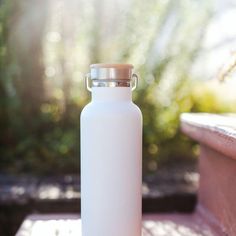 a white water bottle sitting on top of a wooden bench