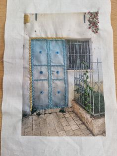 an old photo of a blue door in front of a white building with flowers growing out of it