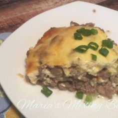 a white plate topped with meat and cheese casserole on top of a table