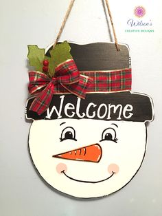 a wooden sign with a snowman wearing a hat and bow on it's head