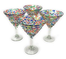 four colorful wine glasses sitting on top of each other in front of a white background