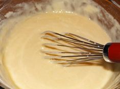 a mixing bowl filled with batter and whisks