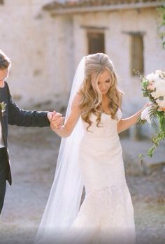 the bride and groom are holding hands