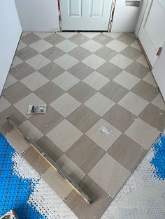 a kitchen floor that is being remodeled with blue and white tiles on the floor, next to a door