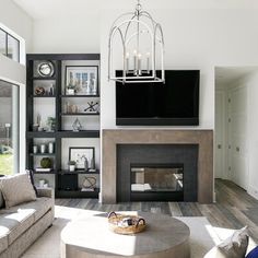 a living room filled with furniture and a flat screen tv mounted above a fire place