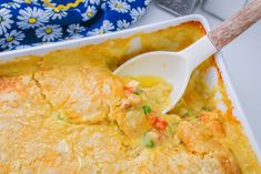 a casserole dish with chicken and vegetables in it is being spooned into the casserole