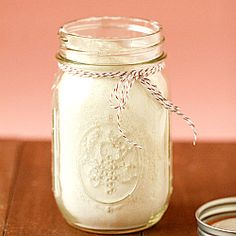 a mason jar filled with white liquid sitting on top of a wooden table