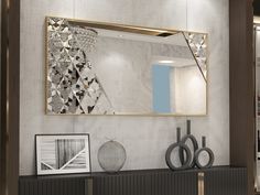 a large mirror is hanging on the wall above a shelf with vases and pictures