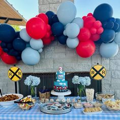 a table topped with lots of food and balloons