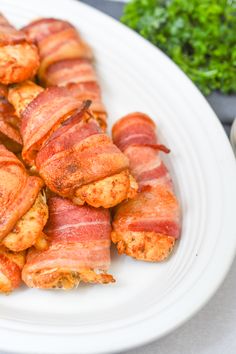 bacon wrapped up in strips on a white plate