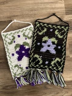 two crocheted bags sitting on top of a wooden floor