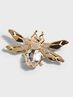 the gold bee brooch is adorned with crystal stones