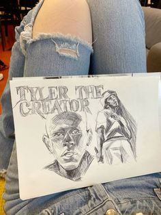 a person holding a sign that says tyler the creator and an image of two people