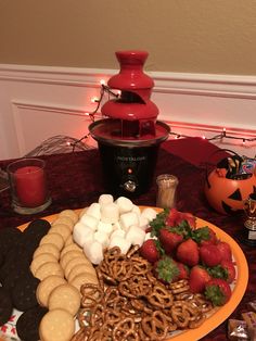 a plate full of pretzels, strawberries, marshmallows and cookies