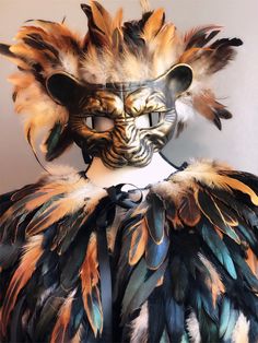 an animal mask with feathers on it