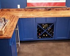 a wine rack in the corner of a kitchen with blue cabinets and countertops