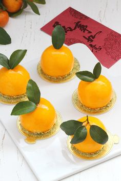 four small orange desserts on a white plate