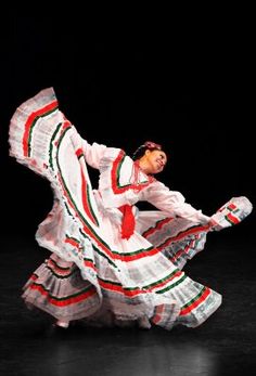 a woman in white and red dress dancing on stage