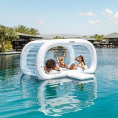 three women are floating in an inflatable pool