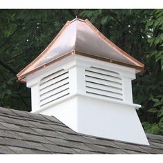 a white cupola on top of a roof with trees in the backgroud