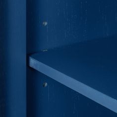 a blue shelf with metal rivets on it