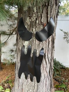 a tree that has been decorated to look like a bat hanging from it's side