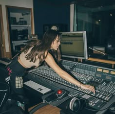 a woman in a recording studio working on sound equipment