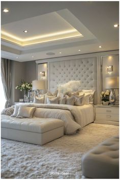 a large white bed sitting in the middle of a bedroom