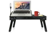 a laptop computer sitting on top of a wooden desk next to a red coffee mug