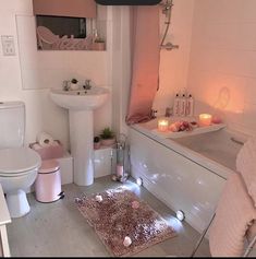 a white bathroom with candles on the floor