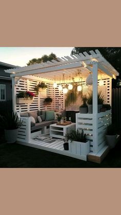 a white pergola with plants and potted plants on the side of it