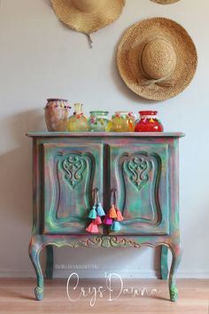 an old dresser has been transformed into a colorful cabinet with tassels on top