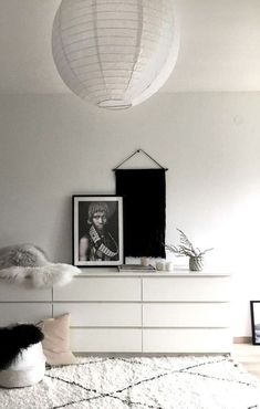 a bedroom with white furniture and a black and white photo on the wall above it