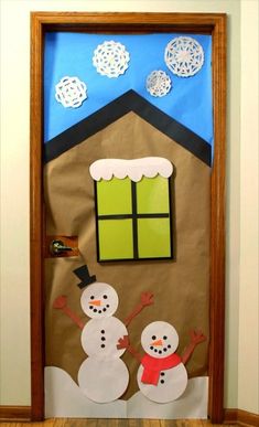 a door decorated with paper snowmen and a house made out of brown paper bags